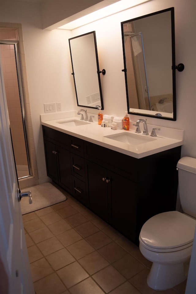 bathroom with toilet, vanity, and tile patterned floors