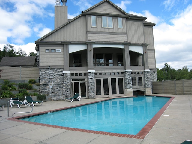 back of property featuring a patio area and a community pool