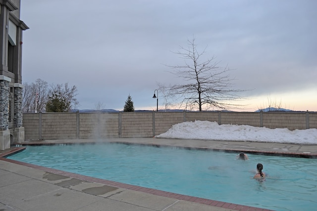 view of pool at dusk