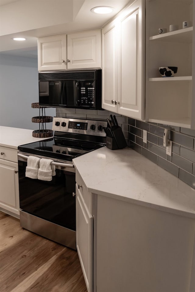 kitchen with stainless steel range with electric cooktop, white cabinetry, tasteful backsplash, wood-type flooring, and light stone countertops