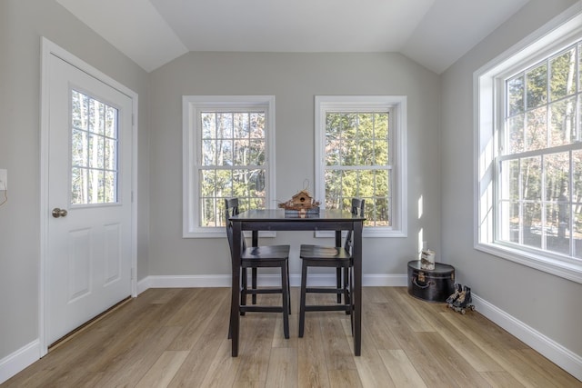 dining room featuring light hardwood / wood-style floors and vaulted ceiling