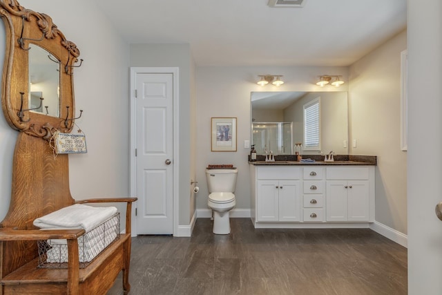 bathroom with toilet, an enclosed shower, and vanity