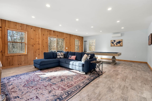 living room with an AC wall unit, billiards, a healthy amount of sunlight, and light hardwood / wood-style flooring