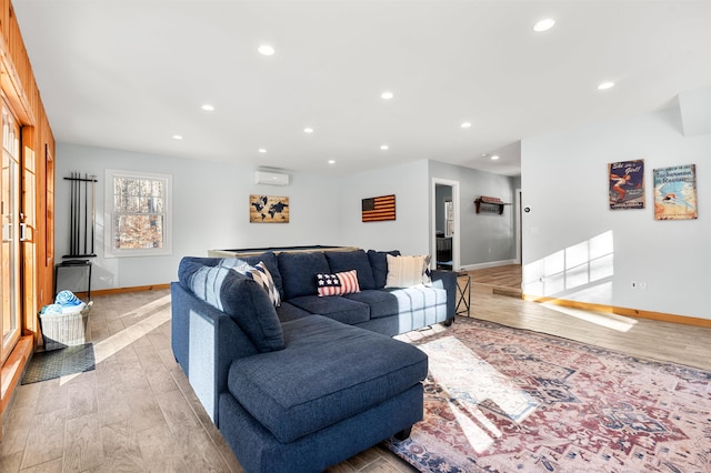 living room with light wood-type flooring and an AC wall unit