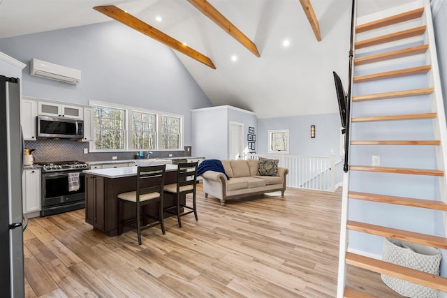 kitchen with stainless steel appliances, a kitchen island, beam ceiling, white cabinets, and a kitchen breakfast bar