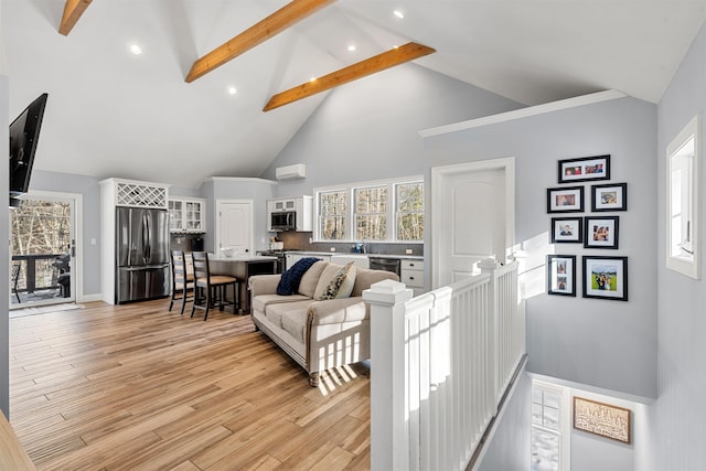 living room with high vaulted ceiling, light hardwood / wood-style floors, and beamed ceiling