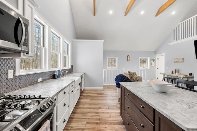 kitchen with appliances with stainless steel finishes, light hardwood / wood-style floors, white cabinetry, and sink