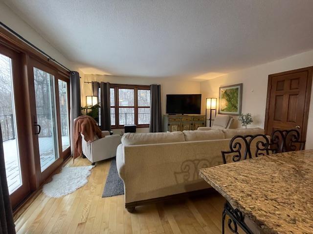 living room with a textured ceiling, light hardwood / wood-style floors, and plenty of natural light