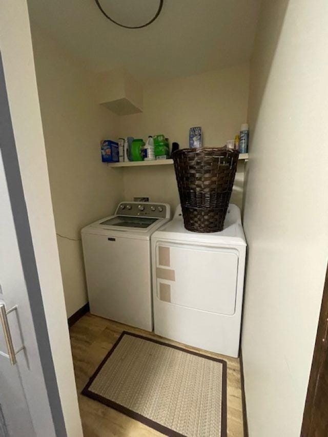 laundry area featuring washer and clothes dryer and light wood-type flooring