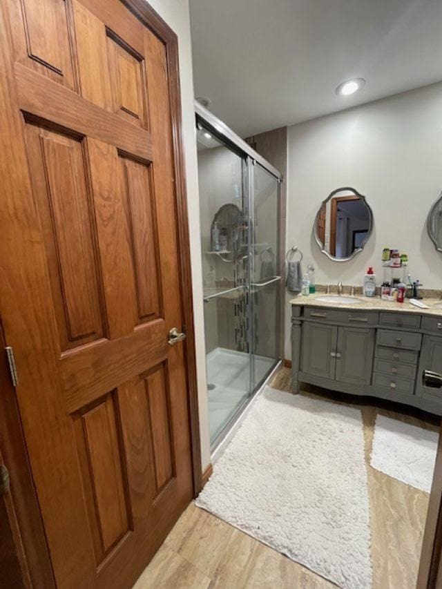 bathroom with vanity, walk in shower, and hardwood / wood-style floors