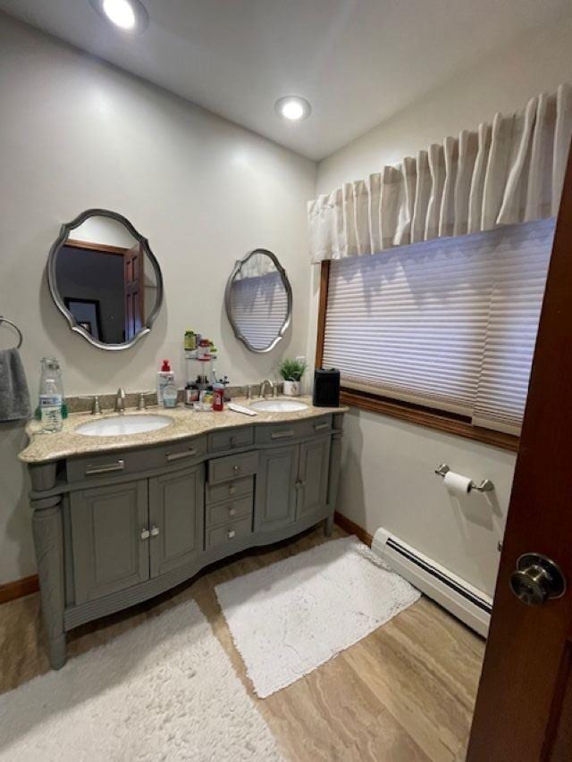 bathroom featuring hardwood / wood-style floors, vanity, and baseboard heating