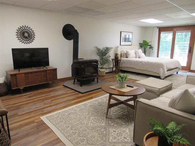 bedroom with a wood stove and hardwood / wood-style floors