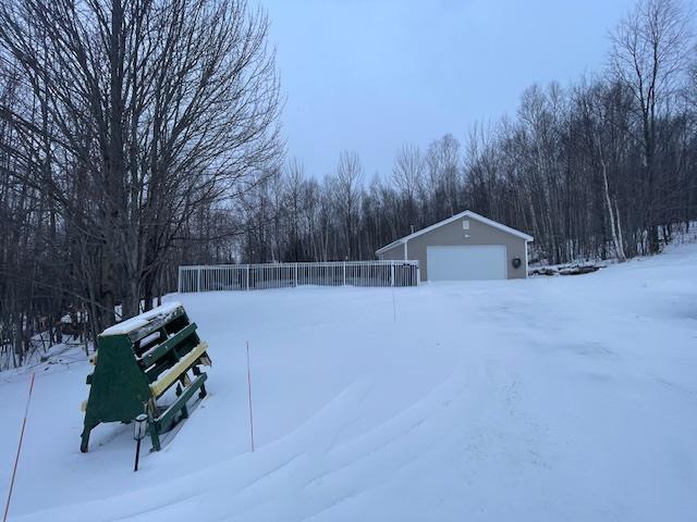 snowy yard with a garage