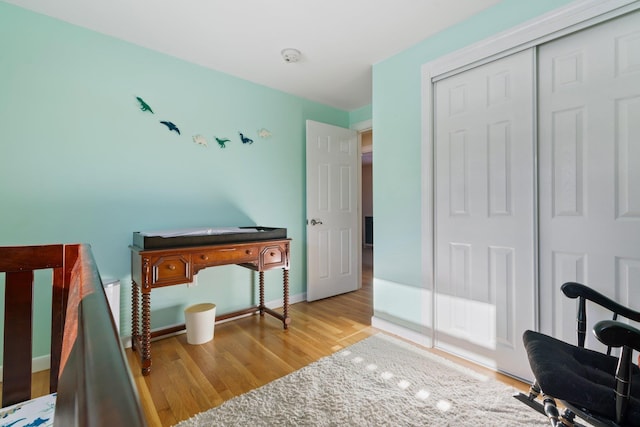 bedroom with light wood-type flooring and a closet