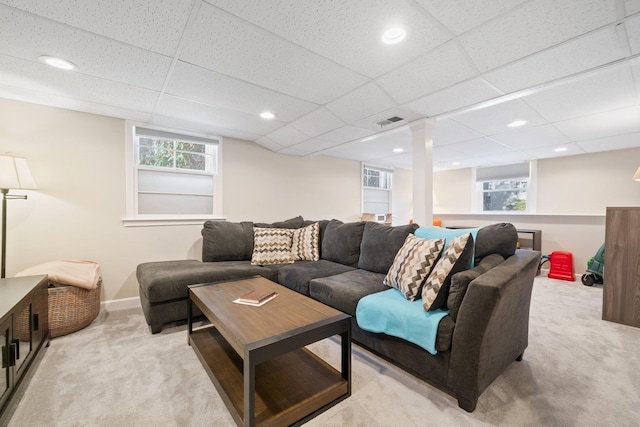 carpeted living room featuring a drop ceiling