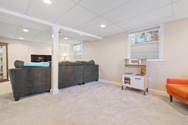 living room with a paneled ceiling and light colored carpet