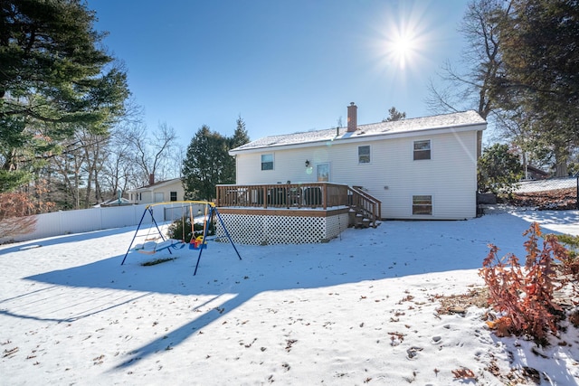 snow covered property featuring a deck and a playground