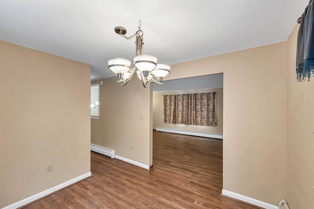 unfurnished dining area with dark hardwood / wood-style flooring, a baseboard heating unit, and an inviting chandelier