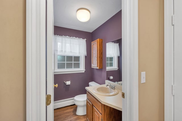 bathroom with toilet, a baseboard radiator, wood-type flooring, and vanity