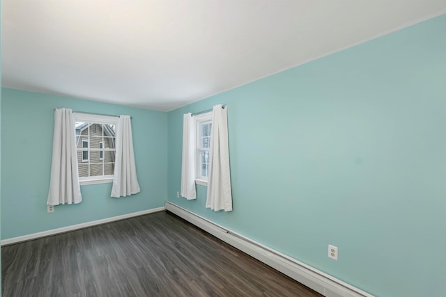 spare room with a baseboard radiator and dark hardwood / wood-style floors