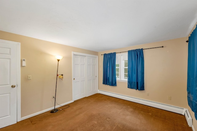 carpeted spare room featuring a baseboard heating unit