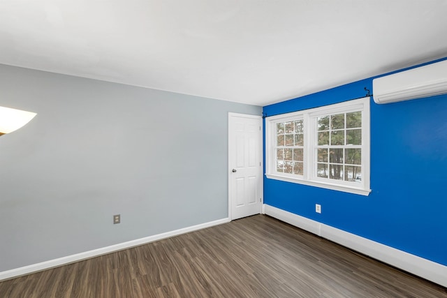 spare room featuring an AC wall unit and wood-type flooring