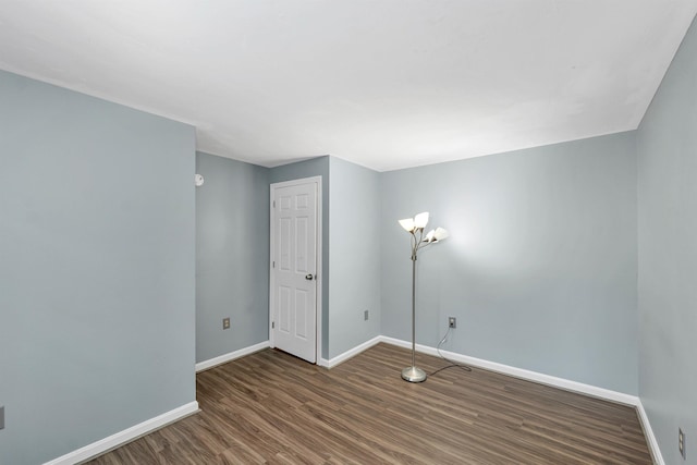 unfurnished room with dark wood-type flooring