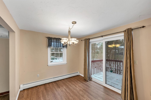 unfurnished dining area with a baseboard heating unit, an inviting chandelier, and hardwood / wood-style flooring