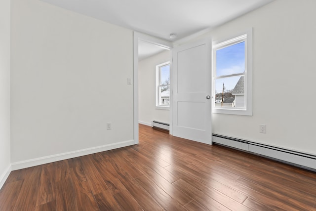 unfurnished room with a baseboard radiator and dark hardwood / wood-style floors