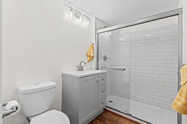 bathroom featuring toilet, a shower with door, and vanity