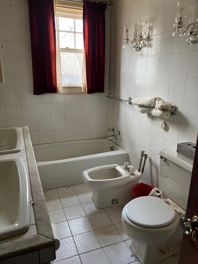 bathroom with a bidet, toilet, a bath, and tile walls