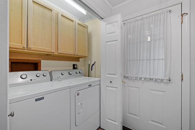 laundry room featuring washer and dryer, cabinets, and crown molding