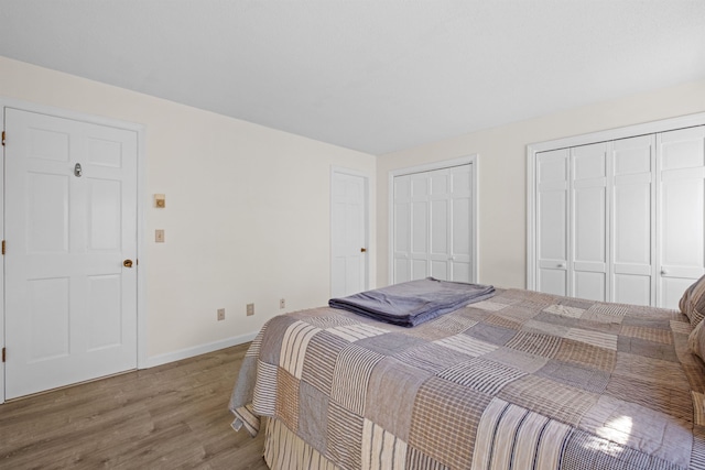 bedroom featuring multiple closets and hardwood / wood-style flooring