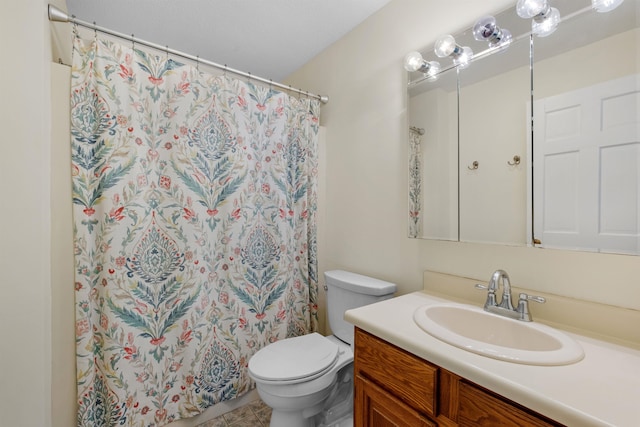 bathroom with toilet, vanity, and tile patterned flooring