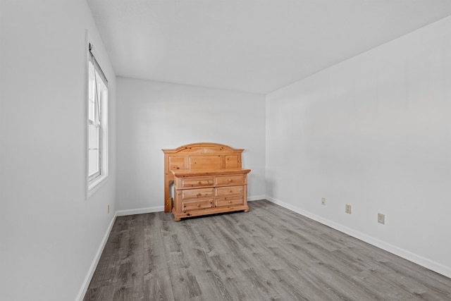 unfurnished bedroom with light wood-type flooring and multiple windows