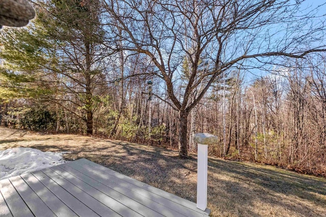 wooden terrace featuring a lawn