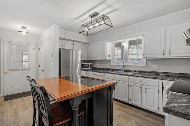 kitchen with stainless steel appliances, white cabinets, a textured ceiling, and sink