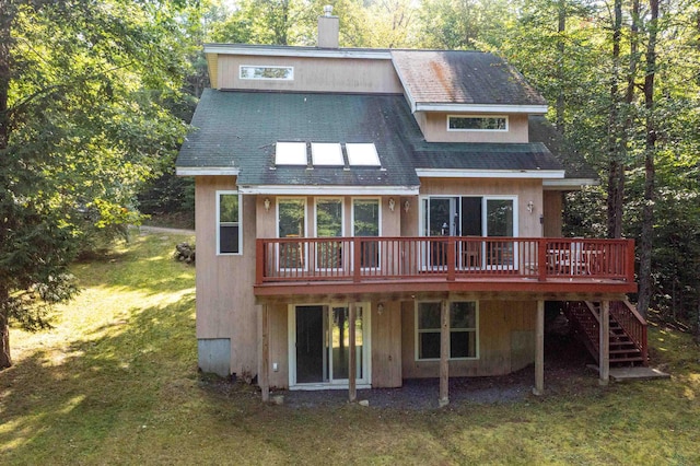 back of property featuring a lawn and a wooden deck