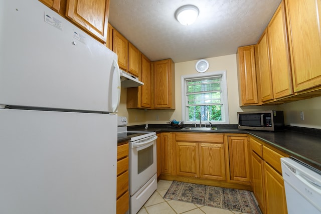 kitchen with white appliances, a textured ceiling, light tile patterned flooring, and sink