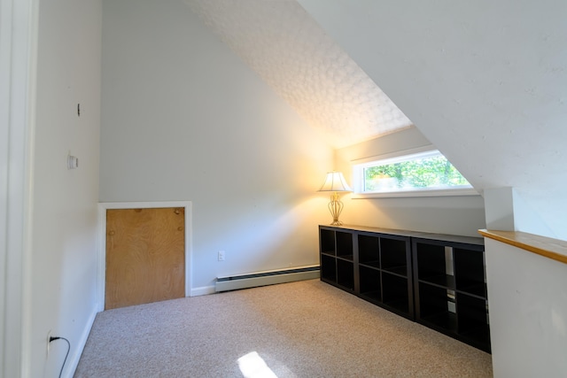 bonus room with a textured ceiling, lofted ceiling, carpet flooring, and a baseboard heating unit