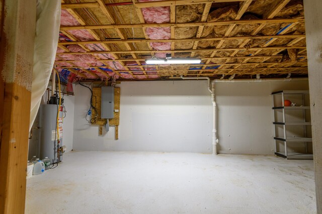 basement featuring electric panel and gas water heater