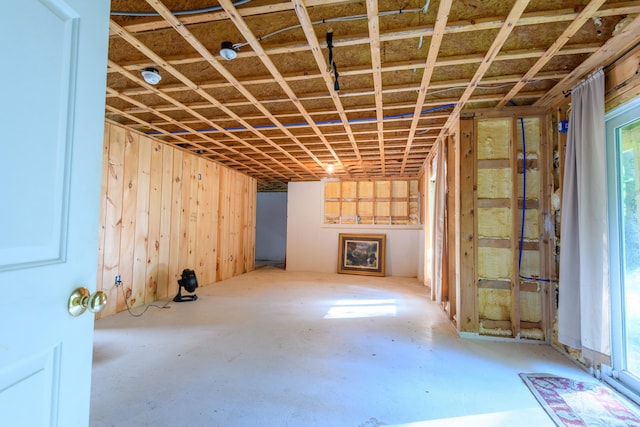 miscellaneous room featuring wood walls and concrete flooring