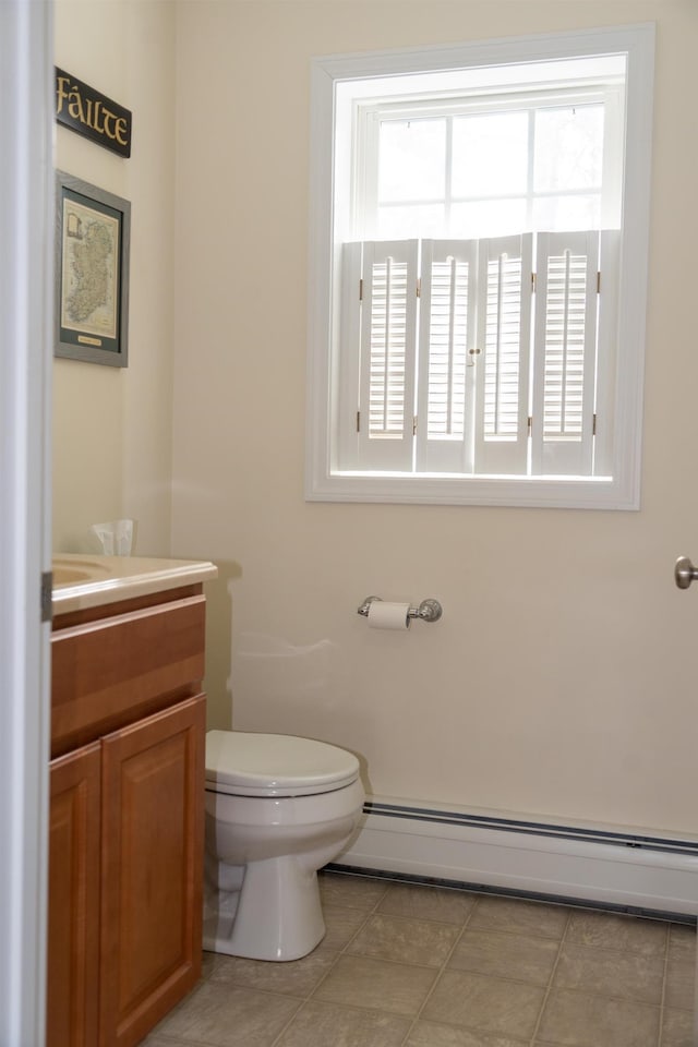 bathroom featuring baseboard heating, tile patterned flooring, vanity, and toilet