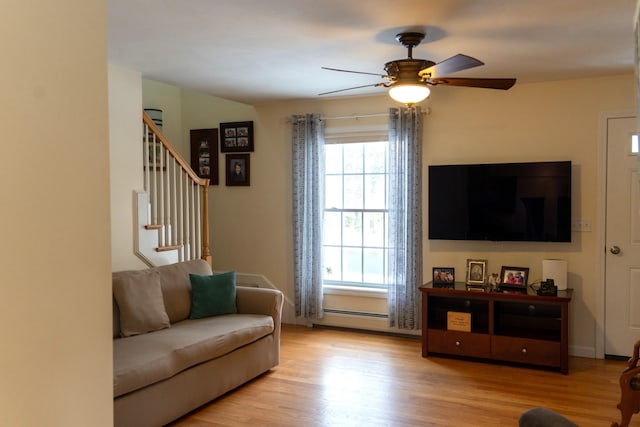 living room with a baseboard radiator, ceiling fan, and light hardwood / wood-style floors