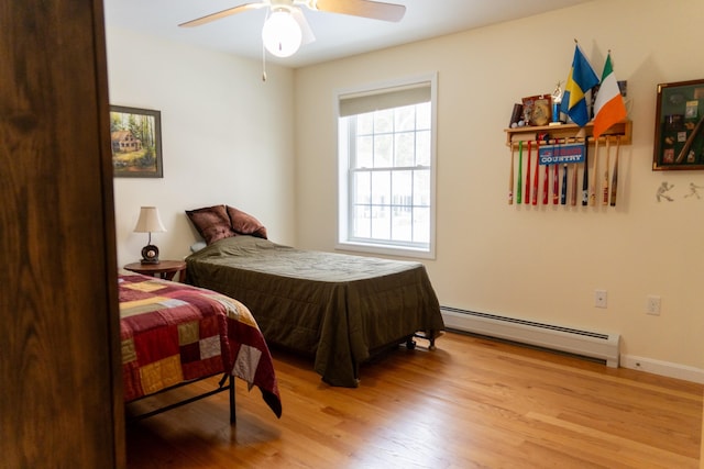 bedroom featuring baseboard heating, ceiling fan, and light wood-type flooring