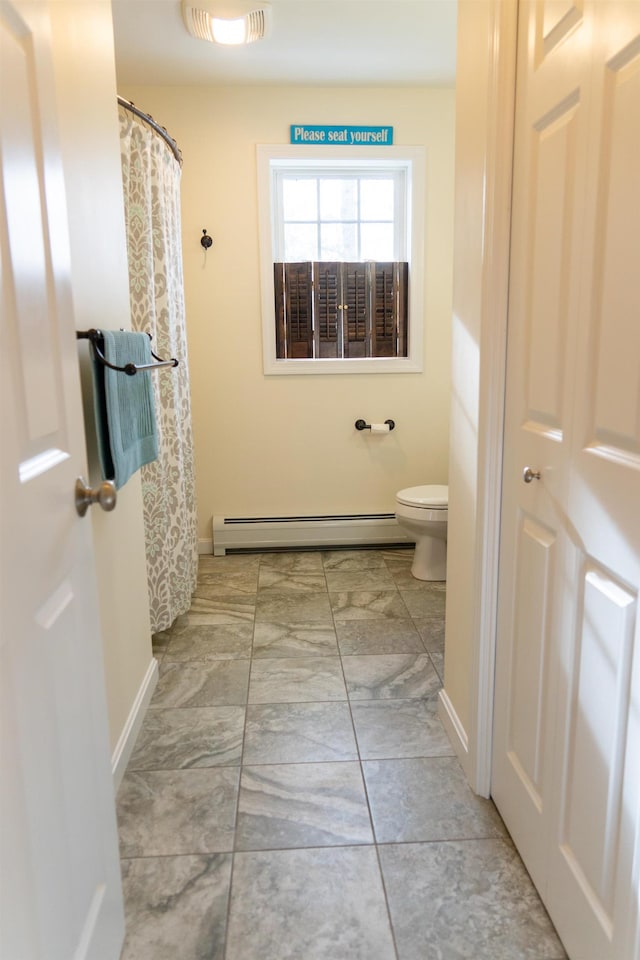 bathroom featuring baseboard heating and toilet