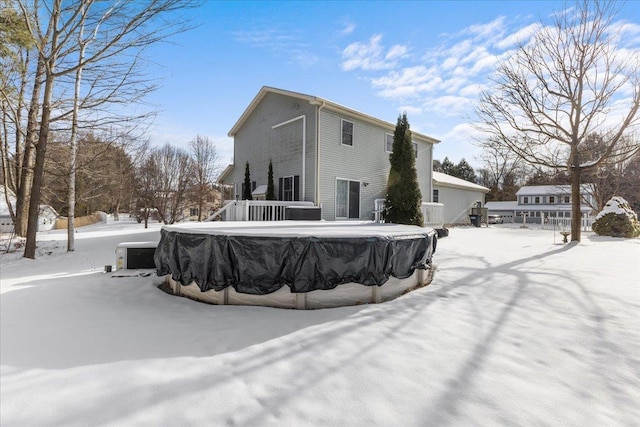 snow covered property with a covered pool