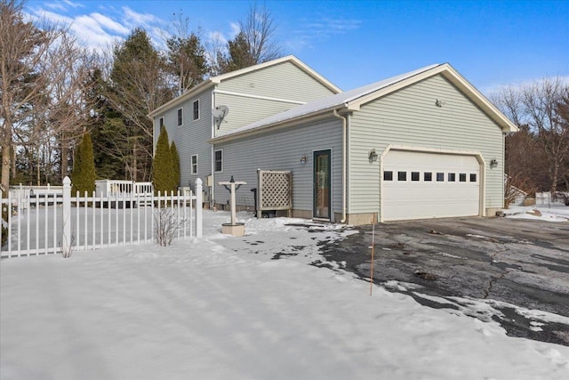 view of snowy exterior with a garage