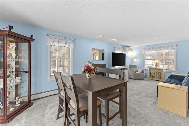 dining room with a baseboard heating unit, an AC wall unit, a textured ceiling, and light colored carpet