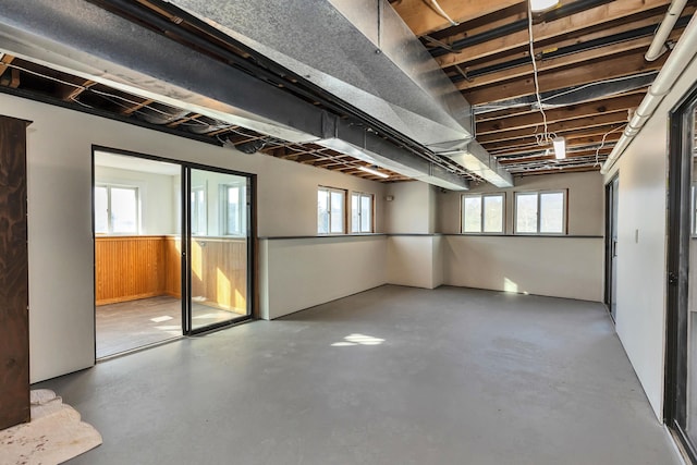 basement featuring a wealth of natural light and wood walls